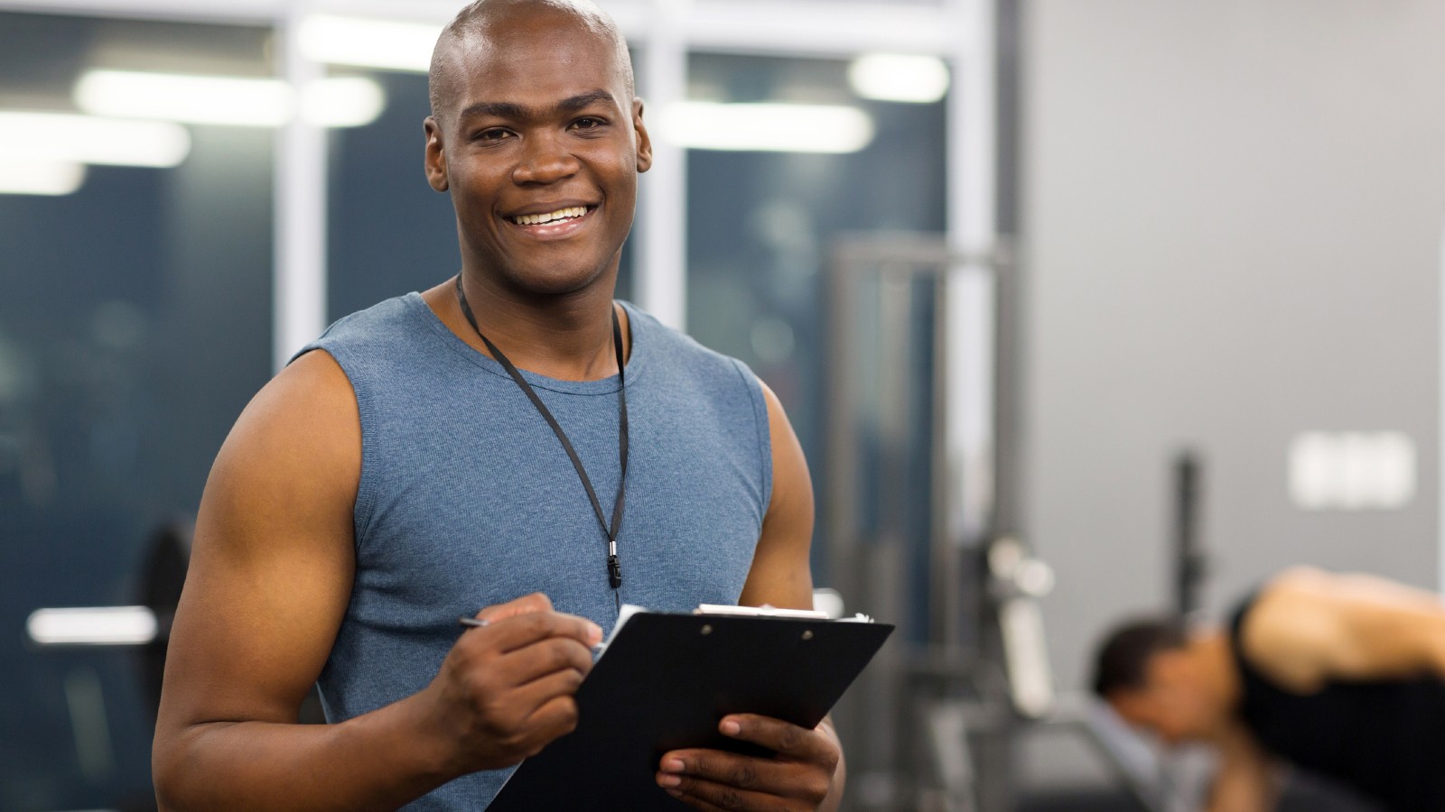 Male fitness professional holding a clipboard